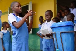 小学校の生徒たちの前で正しい手洗いを実演する子どもたち。 (ナイジェリア、2020年3月18日撮影)