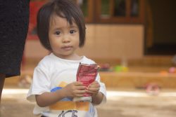 東ヌサ・トゥンガラ州の自宅で、すぐに食べられる栄養治療食(RUTF)を手に持つ、重度の消耗症と診断された1歳のフェリシティちゃん。(インドネシア、2021年2月撮影) 