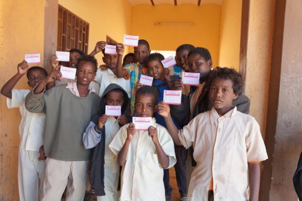 リバーナイル州の学校で、はしかと風しんの予防接種を受けた証明書を手に持つ子どもたち。(スーダン、2024年1月撮影)