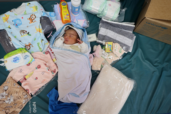 ユニセフから服やおむつなどの新生児に必要不可欠な物資を受け取った、生まれたばかりのウィダッドちゃんと母親。(ガザ地区、2024年4月29日撮影) 