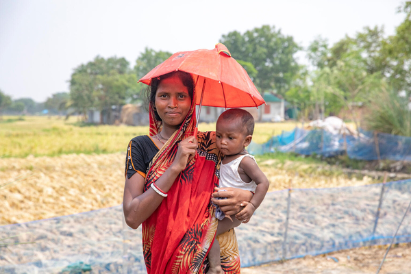 全国的な熱波に見舞われる中、日傘で対策する親子。(バングラデシュ、2024年5月17日撮影)