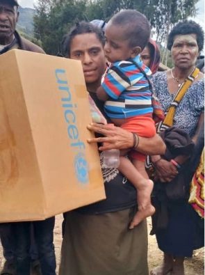 衛生用品などを含む、ユニセフの緊急支援物資を受け取る親子。(パプアニューギニア、2024年5月26日撮影)
