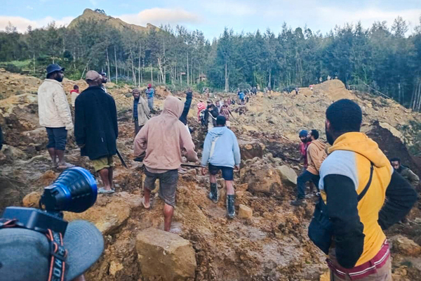地すべりにより被災した村に集まる人たち。地元自治体や人道支援機関などで構成される緊急対応調整チームが、被害状況の把握と支援ニーズを確認している。(パプアニューギニア、2024年5月24日撮影／AFP)
