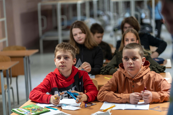 ハルキウにある学校の地下シェルターで授業を受ける12歳のイホールさん(左)。「2年間、自宅でオンライン学習をしていた分を取り戻すために、勉強しています」と話す。(ウクライナ、2024年3月撮影)