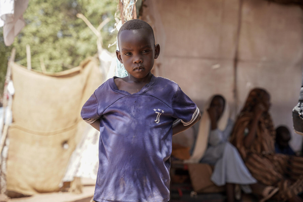 北ダルフールのエルファーシルで起きた武力衝突によって、家族と避難している男の子。(スーダン、2024年5月3日撮影)