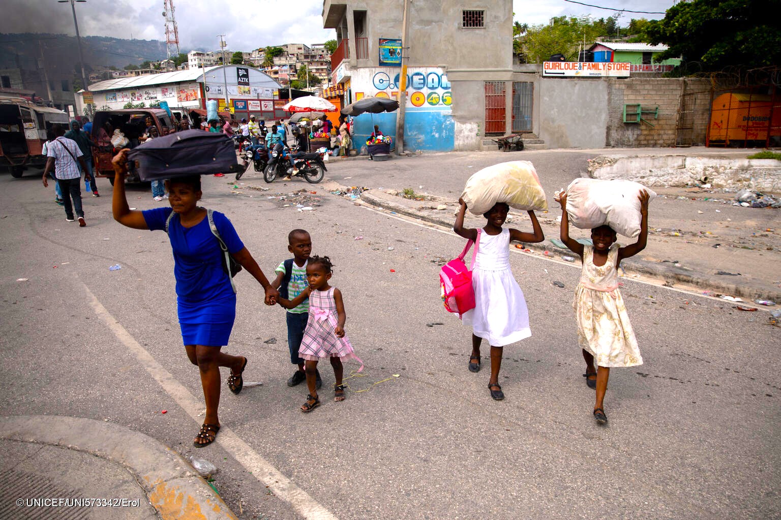 一晩中、自宅近くで銃撃戦があり、わずかな荷物を持って避難する家族。(ハイチ、2024年5月1日撮影)