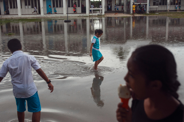 フォンガファレ島で、暴風雨により浸水した小学校の校庭を歩く子どもたち。(ツバル、2023年10月撮影) 