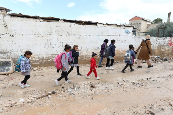 ヨルダン川西岸地区で、破壊された建物の横を通って学校に向かう子どもたち。(パレスチナ、2024年2月9日撮影)