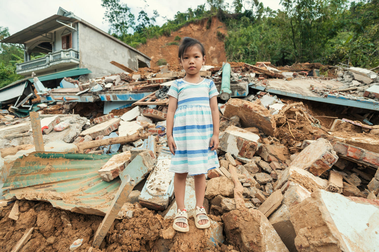 超大型台風「ヤギ」がもたらした豪雨による土砂崩れで、破壊された自宅の前に立つ6歳のカオさん（ベトナム、2024年9月12日）