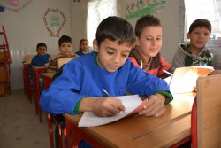 Ahmad, 9, in class at Maysaloon school, Eastern Aleppo. Ahmad is forced to work to support his family.