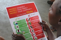 リベリアで、エボラ出血熱の予防法がのったパンフレットを手に取る女性