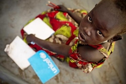 ノートや学用品などの支援物資を受け取った、戦闘で避難を強いられている子ども。（南スーダン）