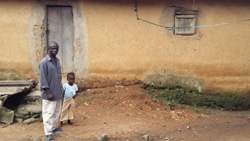 エボラで死亡した妻のお墓のそばで写真を撮ってほしいと頼むウアモウノさんと娘。（ギニア）