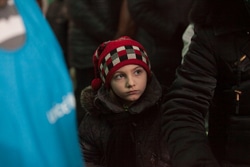 ドネツクで支援物資を受け取る列に並ぶ子ども。（ウクライナ）