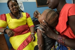 毎月定期的に病院を訪れ、2歳の子どもにHIV治療薬を飲ませる22歳の母親。（シエラレオネ）