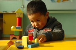 幼稚園で積み木を使って遊ぶ3歳の男の子。（モンゴル）